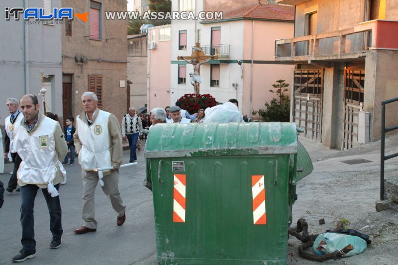 Le vie della processione occupate da auto in sosta e cassonetti di spazzatura